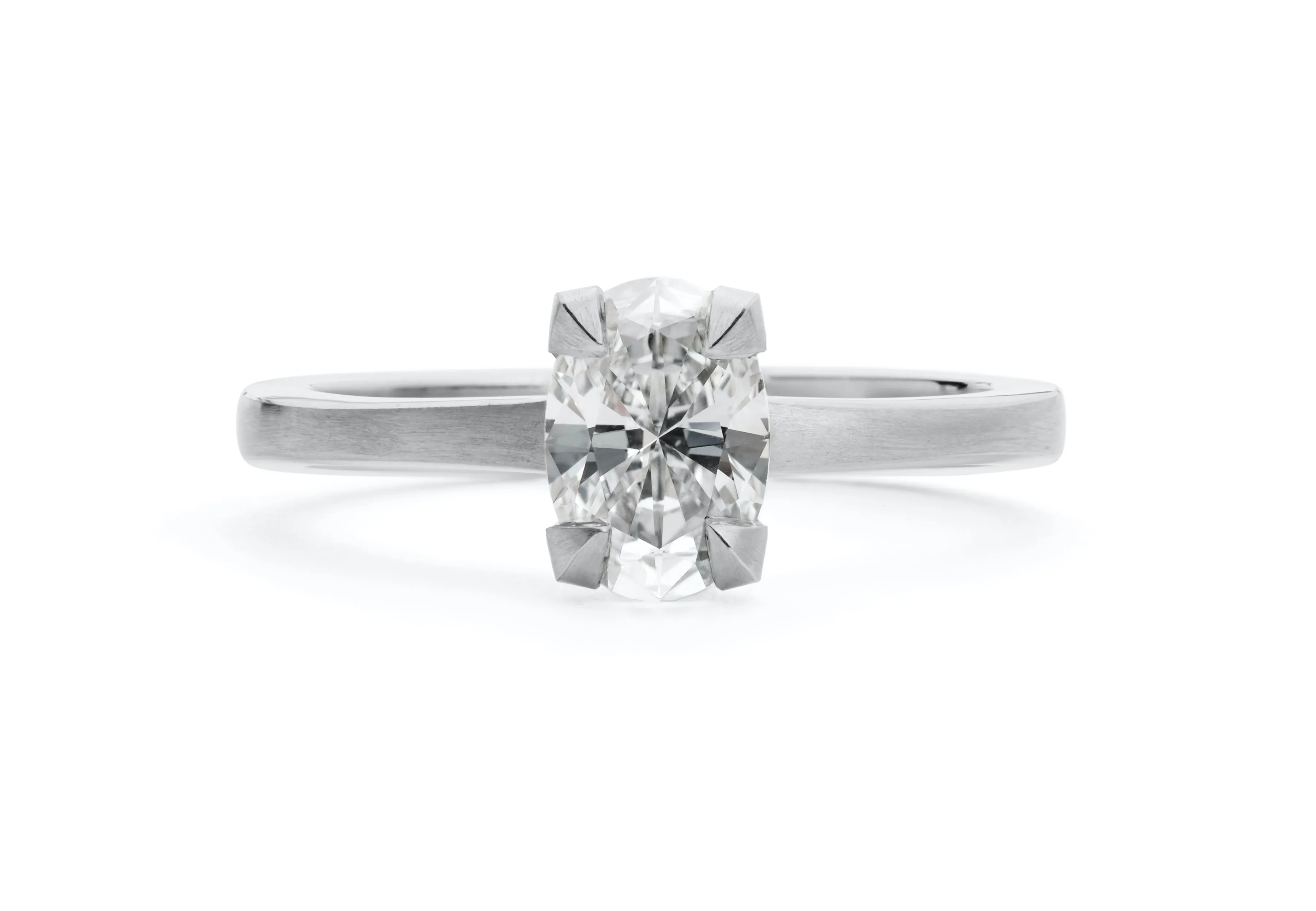 Platinum four claw talon engagement ring with oval white diamond