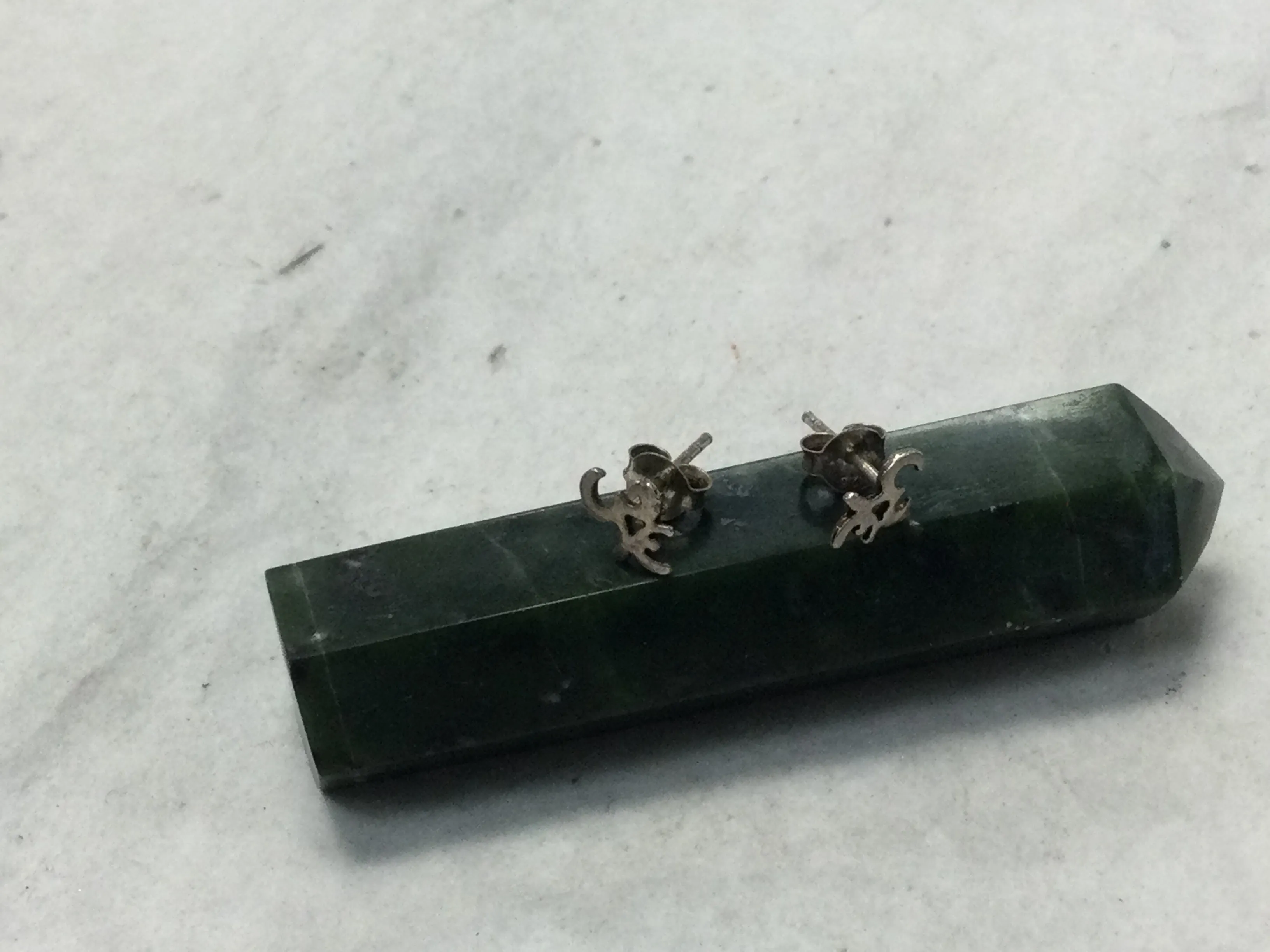 various silver studs (om, feathers, Buddha, etc.)
